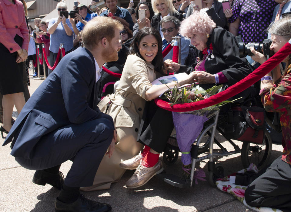 Britain's Prince Harry and Meghan, Duchess of Sussex meet 98-year-old Daphne Dunne during a walkabout outside the Opera House in Sydney, Australia, Tuesday, Oct. 16, 2018. (Paul Edwards/Pool Photo via AP)