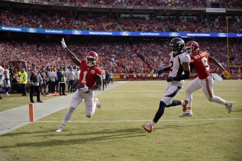 Kansas City Chiefs running back Jerick McKinnon (1) celebrates after scoring past Denver Broncos cornerback Pat Surtain II (2) and teammate JuJu Smith-Schuster (9) during the first half of an NFL football game Sunday, Jan. 1, 2023, in Kansas City, Mo. (AP Photo/Charlie Riedel)