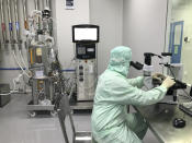 A member of production checks cell growth and viability of a bioreactor sample under an inverted microscope inside the Incepta plant on the outskirts of Dhaka in Bangladesh Saturday Feb. 13, 2021. (AP Photo/Al-emrun Garjon)