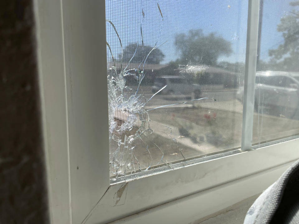 A bullet hole is seen through the bedroom window of Jolene Robledo's home Tuesday, May 16, 2023, in Farmington, N.M. It was among the damage resulting from a deadly shooting along a residential street in the northwestern New Mexico community. (AP Photo/Susan Montoya Bryan)