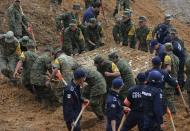 Soldiers lift a portion of a bus out of the mud after it was buried by a mountain landslide in Altotonga in Veracruz state, along Mexico's Gulf coast, September 16, 2013. Twelve people died on Monday after their bus was buried by a mountain landslide near the town of Xaltepec, Governor Javier Duarte told reporters. Two powerful storms pummeled Mexico as they converged from the Pacific and the Gulf on Monday, killing at least 41 people and forcing the evacuation of tens of thousands amid some of the worst flooding in decades. Tropical Depression Ingrid battered Mexico's northern Gulf coast, while the remnants of Tropical Storm Manuel lashed the Pacific coast, inundating the popular beach resort of Acapulco, the U.S. National Hurricane Center (NHC) said. REUTERS/Oscar Martinez