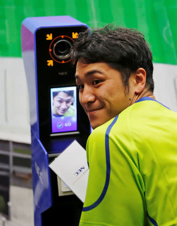 NEC Green Rockets' rugby player Teruya Goto poses with the face recognition system for Tokyo 2020 Olympics and Paralympics, which is developed by NEC corp, during its demonstration in Tokyo, Japan August 7, 2018. REUTERS/Toru Hanai