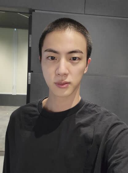 Jin of K-pop band BTS shows off freshly shaved head on the K-pop social media platform Weverse, on Dec. 11, 2022.