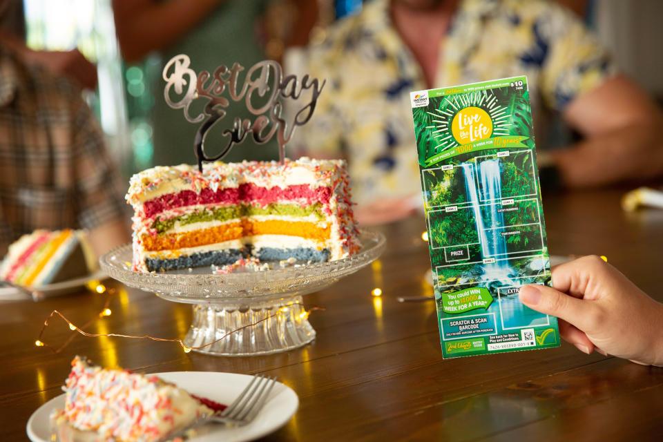 Instant scratchie next to cake with 'best day ever' topper at party