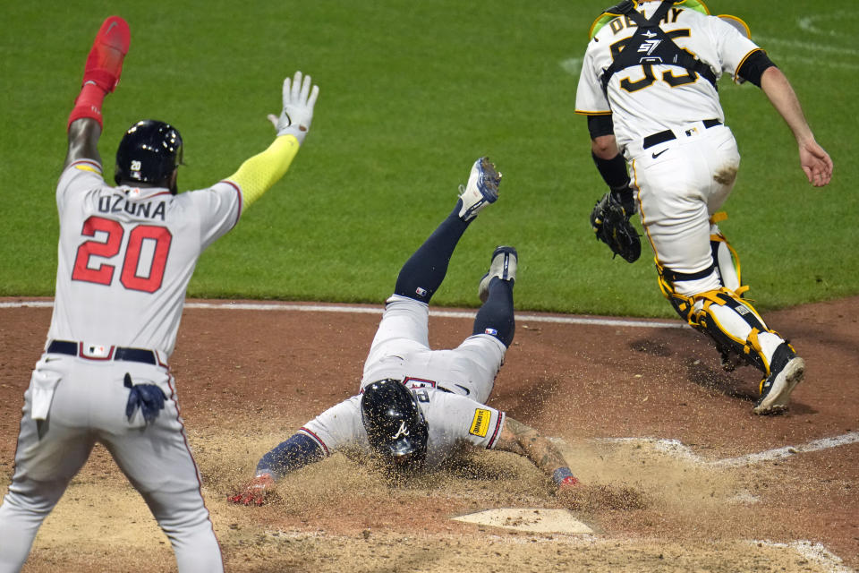 Atlanta Braves' Marcell Ozuna, left, and Kevin Pillar, center, both score on a double by Orlando Arcia off Pittsburgh Pirates relief pitcher David Bednar during the ninth inning of a baseball game in Pittsburgh, Tuesday, Aug. 8, 2023. The Braves won 8-6. (AP Photo/Gene J. Puskar)