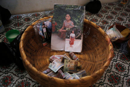 A basket is seen with banknotes and pictures of Claudia Gomez, a 19-year old Guatemalan immigrant who was shot by an U.S. Border Patrol officer, at her home in San Juan Ostuncalco, Guatemala May 27, 2018. REUTERS/Luis Echeverria