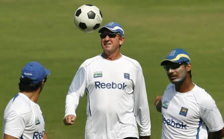 Trevor Bayliss (C) plays with a football as Sri Lanka's captain Kumar Sangakkara (R) warms up during a practice session in the western Indian city of Ahmedabad November 15, 2009 in this file picture. REUTERS/Punit Paranjpe