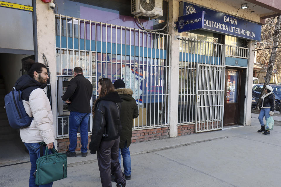 People line up at a cash machine in northern Serb-dominated part of ethnically divided town of Mitrovica, Kosovo, Thursday, Feb. 1, 2024. The European Union on Thursday called on Kosovo to postpone an effort to force ethnic Serbian-dominated areas to adopt the same currency as the rest of the country, as rules that would block use of the Serbian dinar went into effect. Most of Kosovo uses the Euro, even though the country is not part of the EU, but parts of its north populated mostly by ethnic Serbs continue to use the dinar. (AP Photo/Bojan Slavkovic)