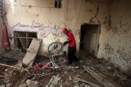 A rescue worker sifts through the rubble after a suicide bomber blew himself up close to a police checkpoint in Peshawar, Pakistan January 19, 2016. REUTERS/Fayaz Aziz