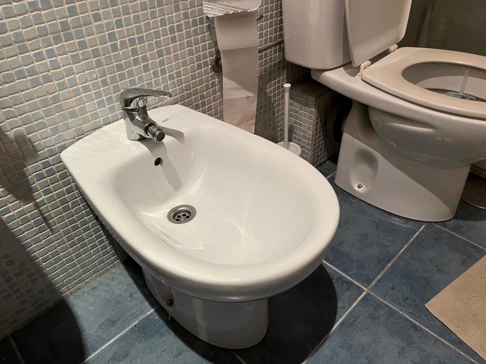 A bidet next to a toilet.