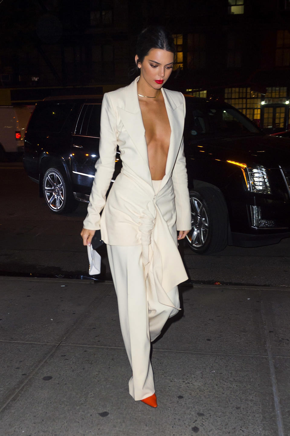 <p>Kendall showcased her figure in a plunging, cream trousers suit, complete with red heels and a matching lip.<br><em>[Photo: Getty]</em> </p>