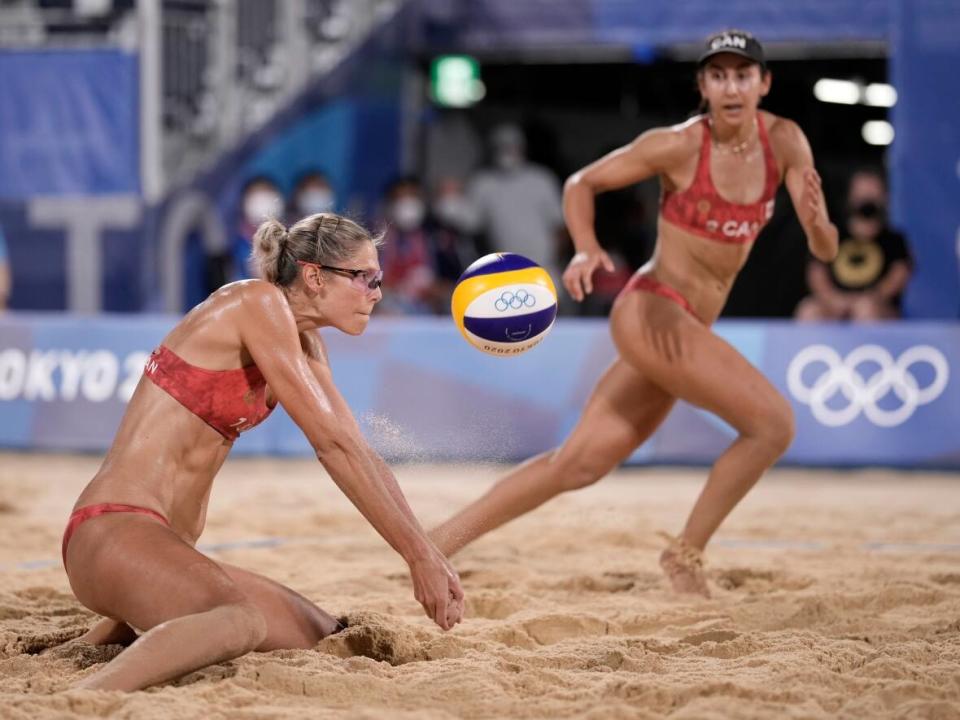 Sarah Pavan, left, and Melissa Humana-Paredes are shown in this August 2021 file photo. The Canadian beach volleyball duo dropped their opening match in Ostrava, Czech Republic on Thursday. (Felipe Dana/The Associated Press  - image credit)