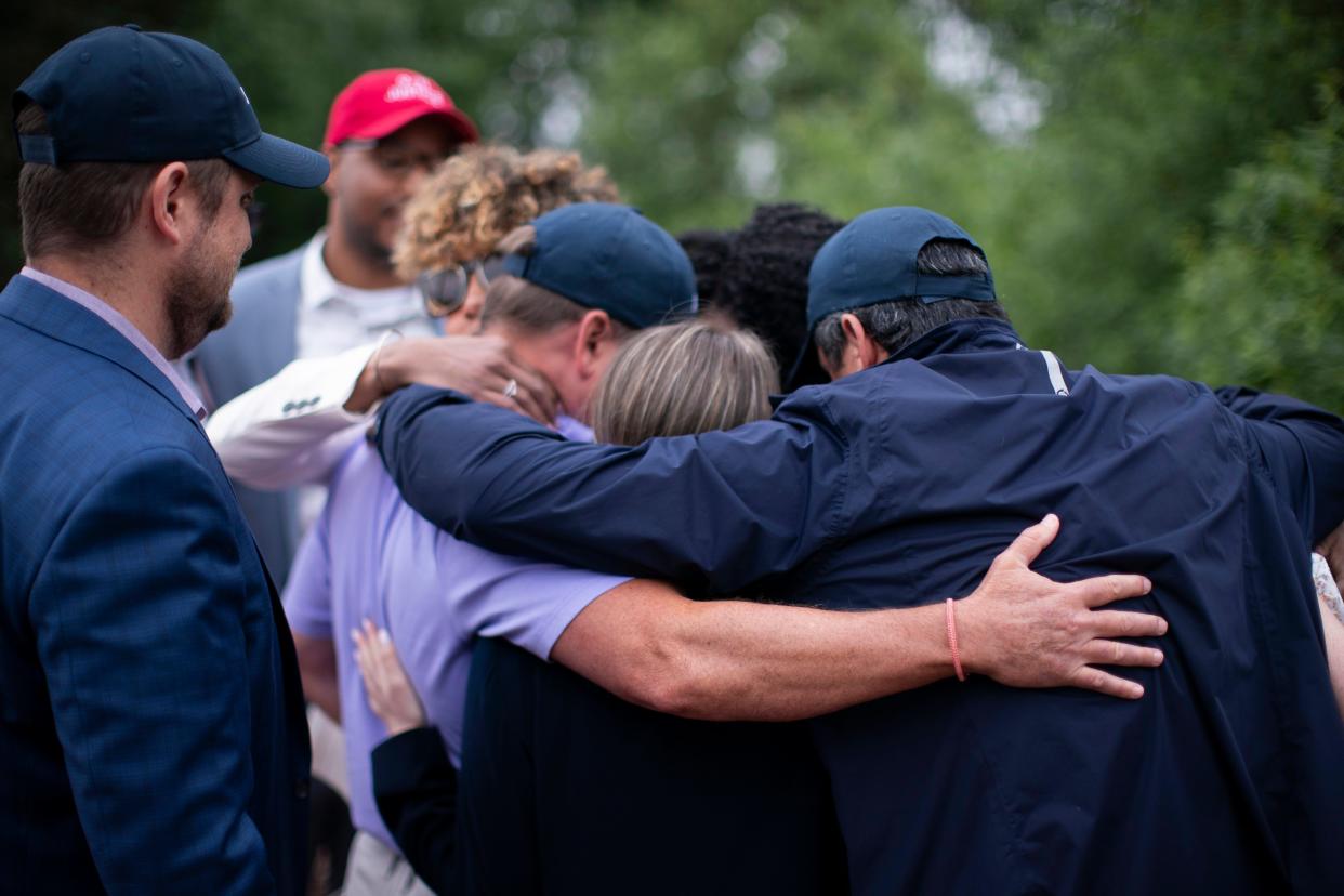 Survivors of the 9/11 attacks and several family members of some of its victims embrace after a news conference at the North Plains Veterans Park in North Plains, Ore., on June 30. The Saudi Arabia-backed LIV Golf tour teed off Thursday, angering a group of families who lost loved ones on Sept. 11 and want the Saudi government held to account for the terrorist attacks.