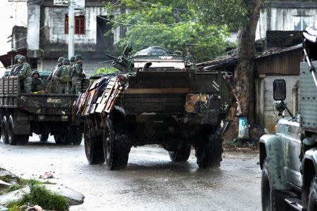 Military vehicles drive along a street while government forces continue their assault on insurgents from the Maute group, in Marawi, Philippines June 26, 2017. REUTERS/Jorge Silva