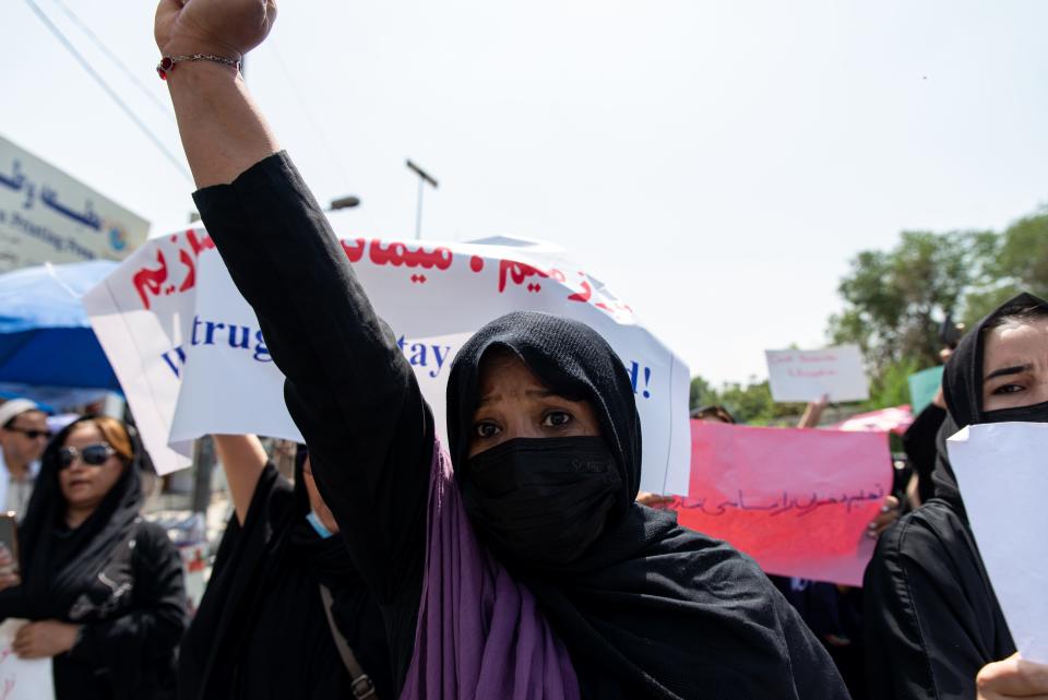 Afghan women chant, "Bread, work and freedom," during a march in front of the education ministry building in Kabul, Afghanistan, on Aug. 13, 2022. Taliban fighters dispersed the rally by firing into the air.