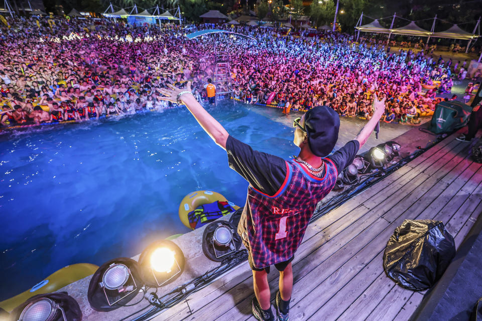 This photo taken on August 15, 2020 shows people watching a performance as they cool off in a swimming pool in Wuhan in China's central Hubei province. (Photo by STR / AFP) / China OUT (Photo by STR/AFP via Getty Images)