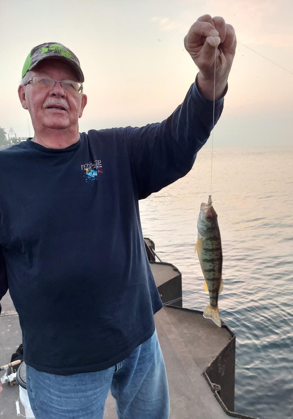 Tim Hansen holds a yellow perch he caught fishing Friday in Lake Michigan on South Pier in Racine.
