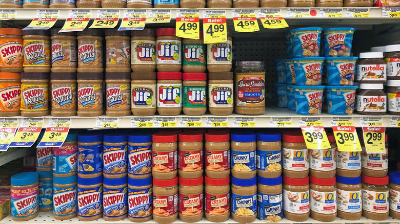 Shelf full of peanut butter spreads from different brands