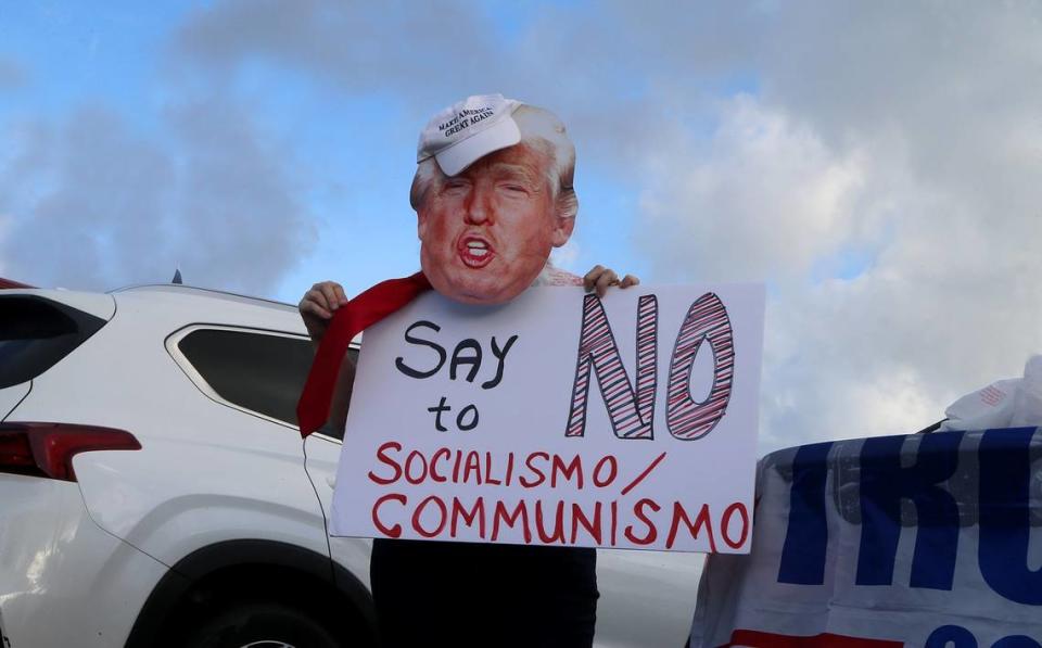 Amelia Bombera, of Coral Gables wears a cut out with President Donald Trump face as she attended an Anti-Communist Caravan for Freedom and Democracy and in support of President Trump, beginning in the Magic City Casinos parking lot at 450 NW 37 Avenue following a route through several Miami streets including SW 8 Street and Flagler Street, on Saturday October 10, 2020.