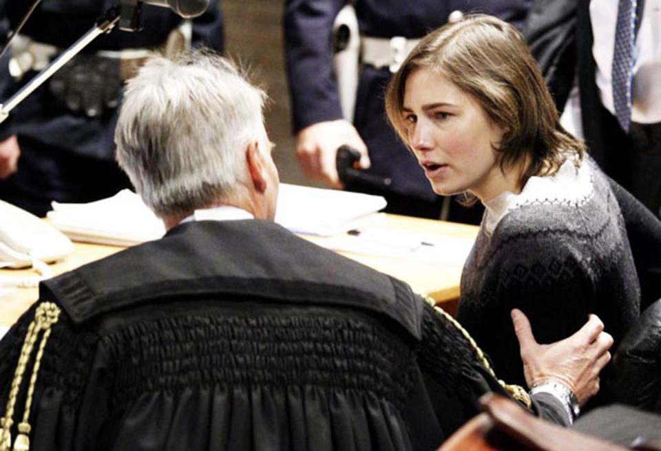Knox speaks to her lawyer Carlo Della Vedova in the courtroom before a trial session (REUTERS)