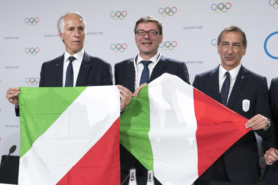 Italian National Olympic Committee (CONI) president Giovanni Malago, Italy's Under Secretary of State Giancarlo Giorgetti and the Mayor of Milan Giuseppe Sala, from left, hold flags during a press conference of the Milan-Cortina candidate cities the first day of the 134th Session of the International Olympic Committee (IOC), at the SwissTech Convention Centre, in Lausanne, Switzerland, Monday, June 24, 2019. The host city of the 2026 Olympic Winter Games will be decided during the134th IOC Session. Stockholm-Are in Sweden and Milan-Cortina in Italy are the two candidate cities for the Olympic Winter Games 2026. (Laurent Gillieron/Keystone via AP)