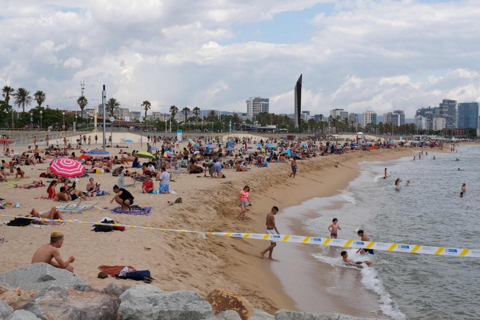 People sunbathe at the Bogatell beach in Barcecola (AFP)