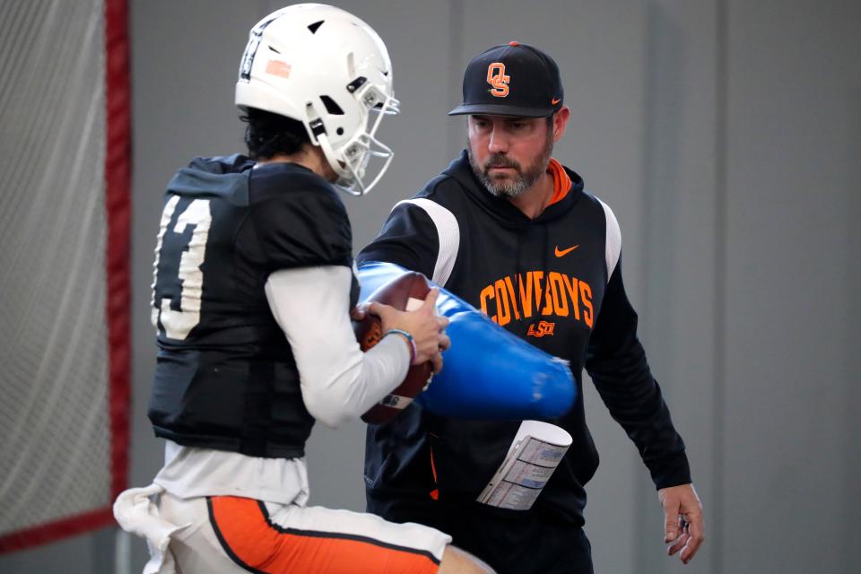 Oklahoma State quarterbacks coach Tim Rattay runs a drill with Garret Rangel during an spring football practice in Stillwater, Okla., Monday, April 17, 2023.