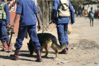 Zimbabwean police with dogs patrol a neighbourhood, in Harare, Friday, July, 31, 2020. Zimbabwe's capital, Harare, was deserted Friday, as security agents vigorously enforced the country's lockdown amidst planned protests. Police and soldiers manned checkpoints and ordered people seeking to get into the city for work and other chores to return home. (AP Photo/Tsvangirayi Mukwazhi)