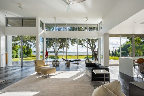 Sliding glass doors wrap around the rear of the home, framing striking lakefront views.