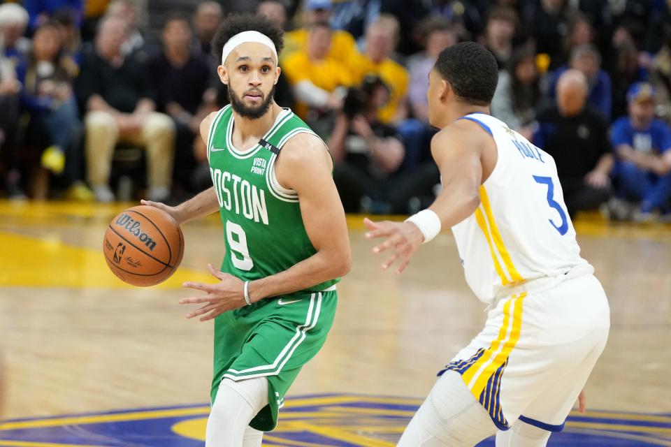 Celtics guard Derrick White (9) dribbles the ball while defended by Golden State Warriors guard Jordan Poole (3) during the second half of Game 1.