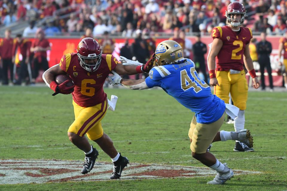 USC running back Vavae Malepeai runs the ball against UCLA linebacker Caleb Johnson.