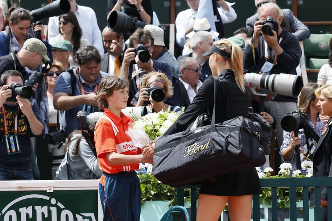 Russia's Maria Sharapova is offered flowers as she arrives on the court prior to play against Italy's Sara Errani their Women's Singles final tennis match of the French Open tennis tournament at the Roland Garros stadium, on June 9, 2012 in Paris. AFP PHOTO / JACQUES DEMARTHONJACQUES DEMARTHON/AFP/GettyImages