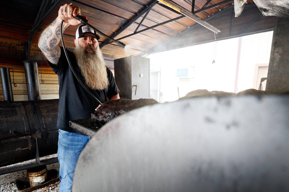 Shawn Thatcher uses a pressurized sprayer to put his sauce on a brisket on Sunday, June 12, 2022, at Thatcher Barbecue Comapny in Slade, Kentucky.
