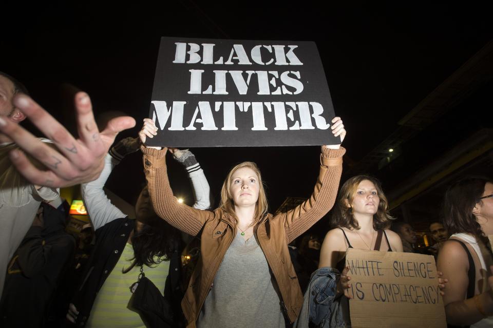 Protesters march with signs during a protest against police violence in the U.S., in Berkeley, California