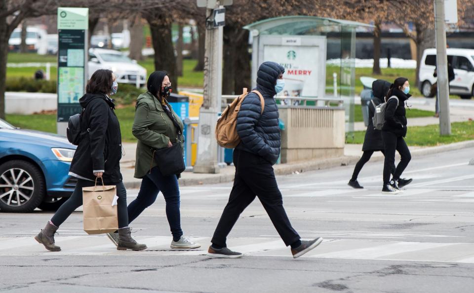 TORONTO, Nov. 24, 2020 -- People wearing face masks cross a street in Toronto, Canada, on Nov. 24, 2020. The number of COVID-19 cases in Canada continued to increase as the country reported a total of 340,388 cases and 11,592 deaths as of Tuesday afternoon, according to CTV. (Photo by Zou Zheng/Xinhua via Getty) (Xinhua/Zou Zheng via Getty Images)