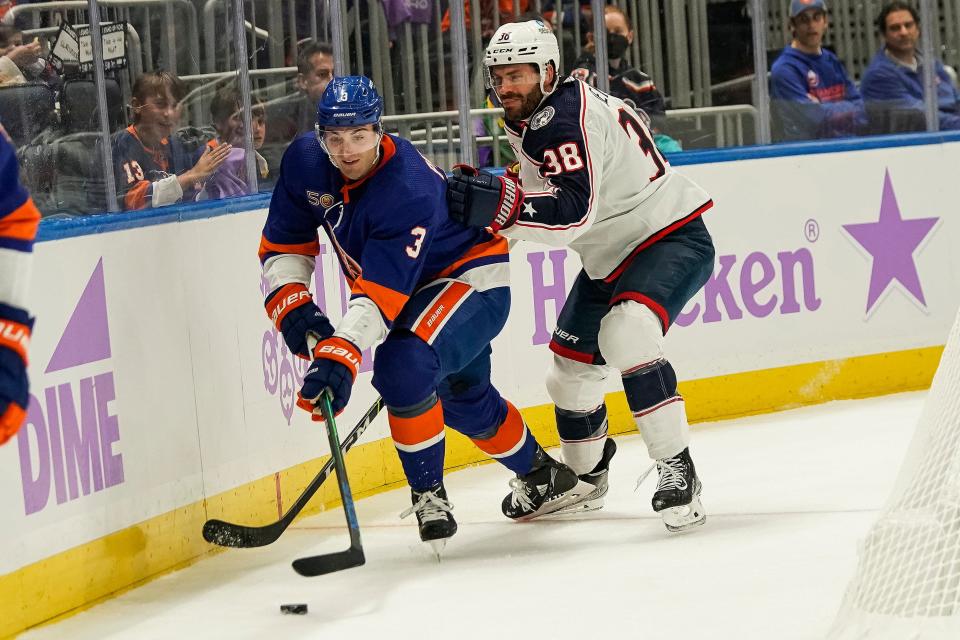New York Islanders defenseman Adam Pelech (3) and Columbus Blue Jackets centerman Boone Jenner (38) fights for control of the puck during the first period of a NHL hockey game, Saturday, Nov. 12, 2022, in Elmont, N.Y. (AP Photo/Eduardo Munoz Alvarez)