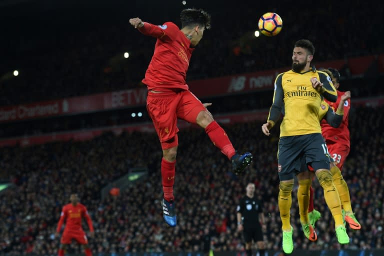 Liverpool's midfielder Roberto Firmino (C) heads the ball across goal during the English Premier League football match against Arsenal March 4, 2017