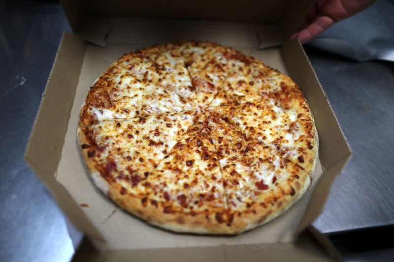 A pizza comes out of the oven at Domino's Pizza restaurant in Los Angeles