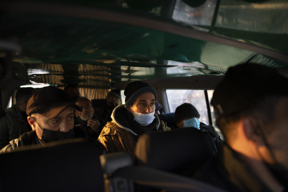 Palestinians sits in a minibus on their way to work, after crossing from Gaza to Israel, on the Israeli side of Erez crossing between Israel and the Gaza Strip, March. 27, 2022. Israel said it will reopen its crossing with the Gaza Strip to Palestinian workers on Tuesday, April 26, 2022, after it had been closed for several days following rocket attacks from the Palestinian enclave. Israel has issued thousands of work permits to Palestinians from Gaza, which has been under a crippling Israeli and Egyptian blockade since Hamas seized power from rival Palestinian forces nearly 15 years ago. (AP Photo/Oded Balilty)