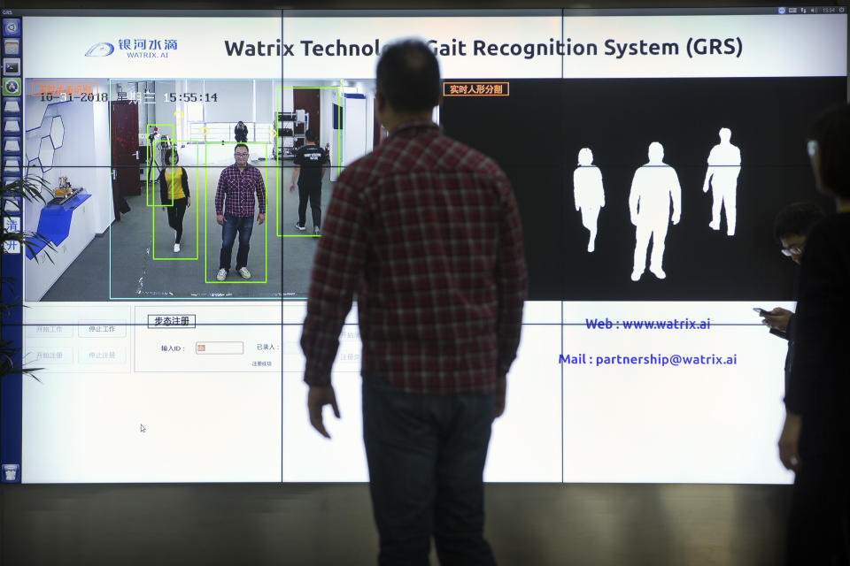 In this Oct. 31, 2018, photo, Watrix employees demonstrate their firm's gait recognition software at their company's offices in Beijing. A Chinese technology startup hopes to begin selling software that recognizes people by their body shape and how they walk, enabling identification when faces are hidden from cameras. Already used by police on the streets of Beijing and Shanghai, “gait recognition” is part of a major push to develop artificial-intelligence and data-driven surveillance across China, raising concern about how far the technology will go. (AP Photo/Mark Schiefelbein)