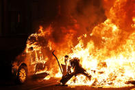 A car catches fire next to a burning barricade during clashes between protestors and police in Barcelona, Spain, Wednesday, Oct. 16, 2019. Spain's government said Wednesday it would do whatever it takes to stamp out violence in Catalonia, where clashes between regional independence supporters and police have injured more than 200 people in two days. (AP Photo/Bernat Armangue)