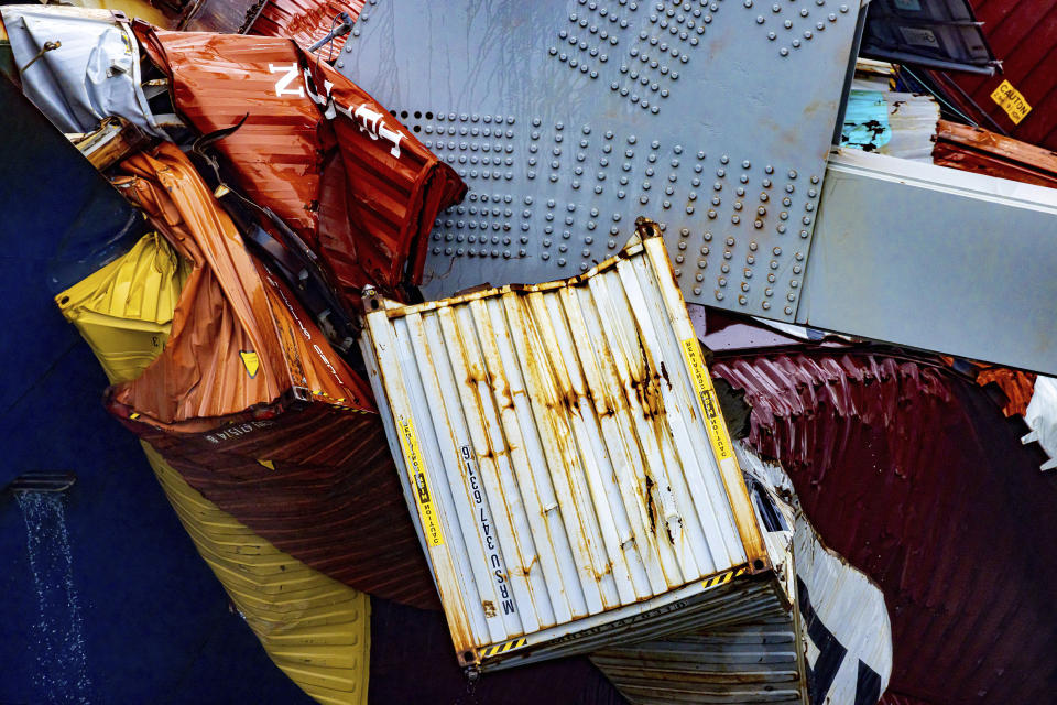 Containers are crushed as wreckage of the Francis Scott Key Bridge rests on the container ship Dali, Wednesday, April 3, 2024, in Baltimore. (AP Photo/Julia Nikhinson)