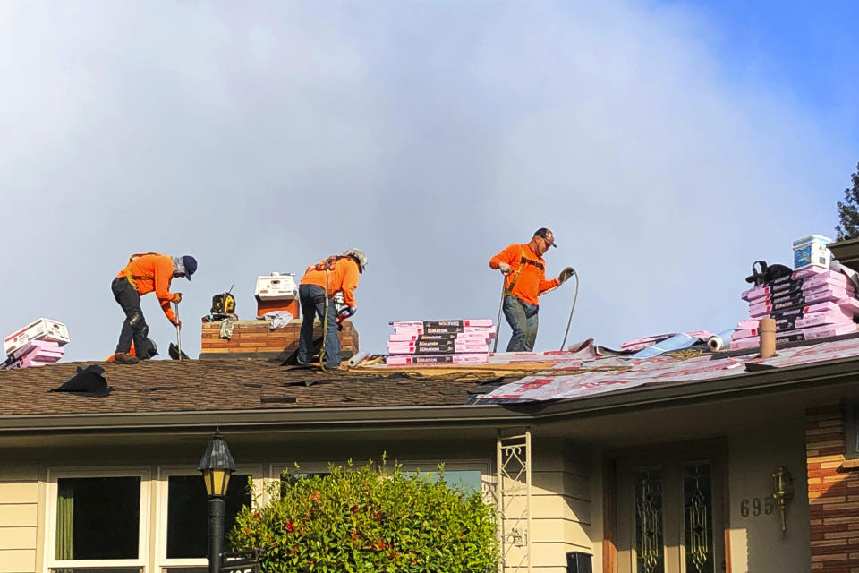 Roofers work on a home in Salem, Ore., Tuesday, May 5, 2020. Oregon Gov. Kate Brown has allowed construction to continue under her stay-home order. (AP Photo/Andrew Selsky)