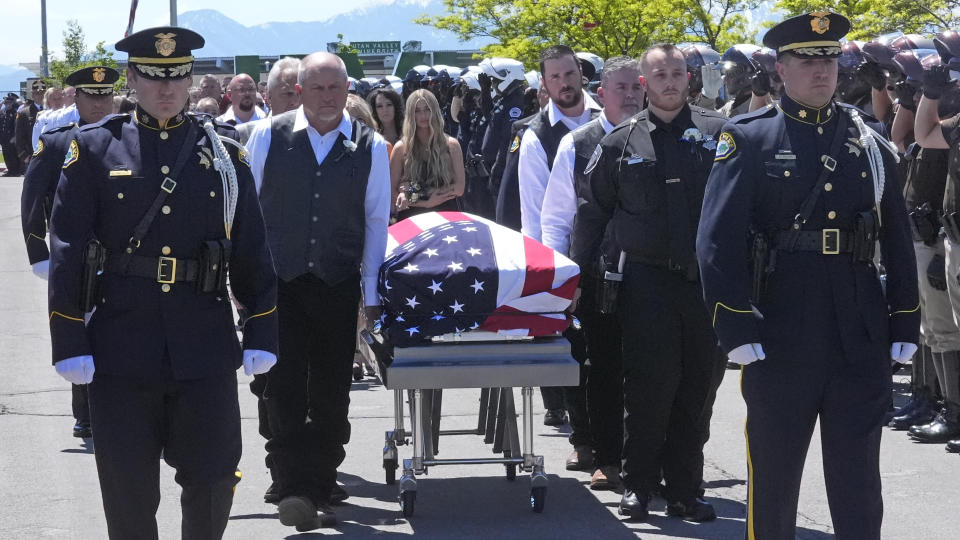 The casket of Santaquin Police Sgt. Bill Hooser is carried from Utah Valley University Monday, May 13, 2024, in Orem, Utah. Hooser was killed on May 5, 2024, while helping a Utah Highway Patrol trooper with a traffic stop when police say a man driving a semi-trailer intentionally hit Hooser. (AP Photo/Rick Bowmer)