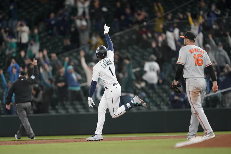 Seattle Mariners' Kyle Lewis celebrates after he hit a three-run home run as Baltimore Orioles first baseman Trey Mancini looks on during the eighth inning of a baseball game, Tuesday, May 4, 2021, in Seattle. (AP Photo/Ted S. Warren)