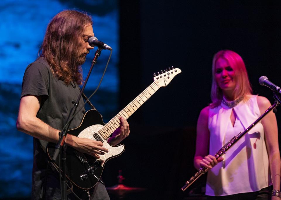 Guitarist Mike Dawes, left, plays as flutist Karmen Gould looks on.