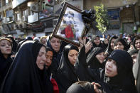 Families of victims of Saturday's terror attack on a military parade in the southwestern city of Ahvaz, that killed 25 people attend a mass funeral ceremony, in Ahvaz, Iran, Monday, Sept. 24, 2018. Thousands of mourners gathered at the Sarallah Mosque on Ahvaz's Taleghani junction, carrying caskets in the sweltering heat. (AP Photo/Ebrahim Noroozi)