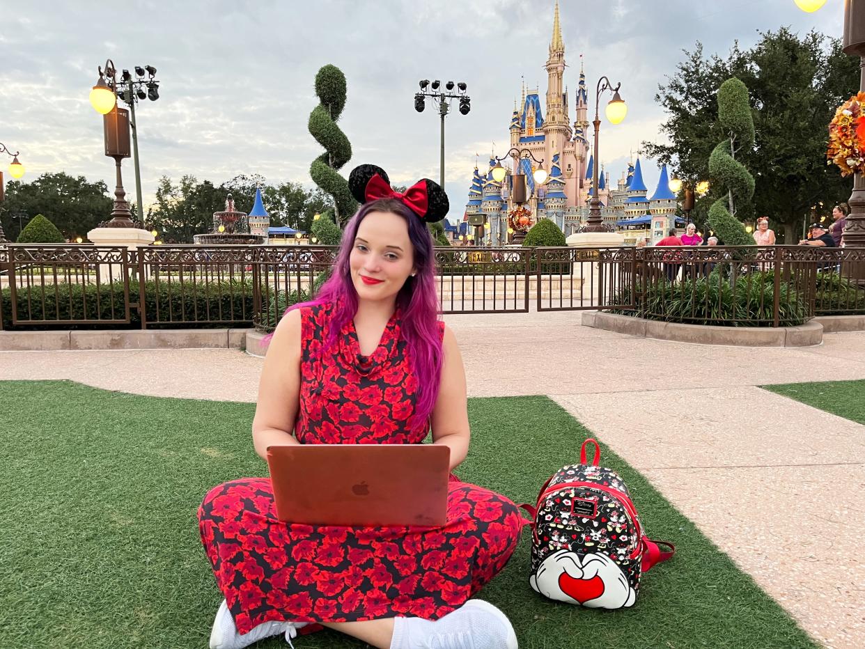 jenna in front of magic kingdom with laptop