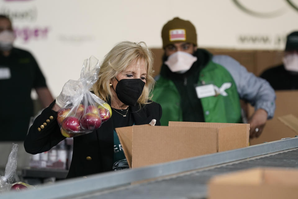 First lady Jill Biden packs produce as she and President Joe Biden volunteer at hunger relief organization Philabundance, Sunday, Jan. 16, 2022, in Philadelphia. (AP Photo/Patrick Semansky)