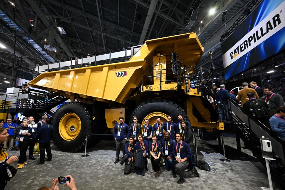 People take pictures with a fully autonomous Caterpillar Inc. 777 mining haul truck displayed at the company's booth during the Consumer Electronics Show (CES) in Las Vegas, Nevada, on January 5, 2023. (Photo by Patrick T. Fallon / AFP) (Photo by PATRICK T. FALLON/AFP via Getty Images)